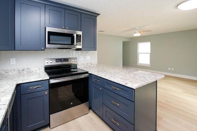 kitchen featuring backsplash, blue cabinets, light hardwood / wood-style flooring, appliances with stainless steel finishes, and kitchen peninsula