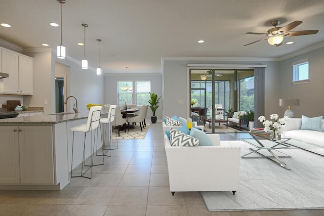 living area featuring recessed lighting, ornamental molding, and ceiling fan