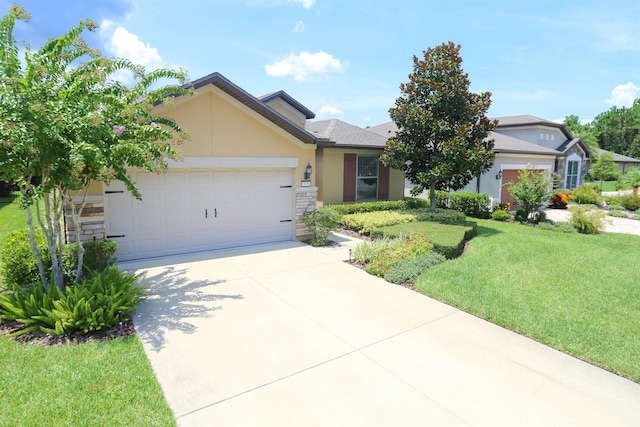 ranch-style home with driveway, stone siding, a front yard, an attached garage, and stucco siding