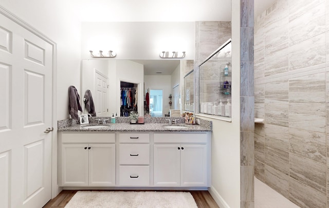 59 Oakleaf Way, Palm Coast, FL 32137 - bathroom with walk in shower, double vanity, wood finished floors, and a sink