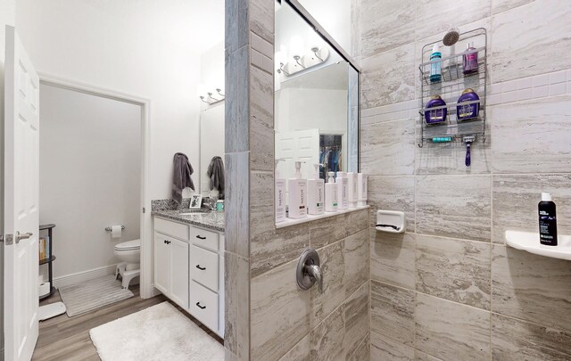 59 Oakleaf Way, Palm Coast, FL 32137 - full bathroom featuring vanity, toilet, wood finished floors, and a tile shower