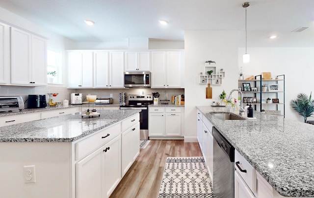 59 Oakleaf Way, Palm Coast, FL 32137 - kitchen featuring a sink, stainless steel appliances, visible vents, backsplash, and light wood-style floors