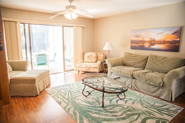 living room with ceiling fan, hardwood / wood-style floors, and a textured ceiling