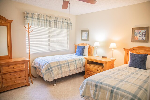 carpeted bedroom featuring a textured ceiling and ceiling fan