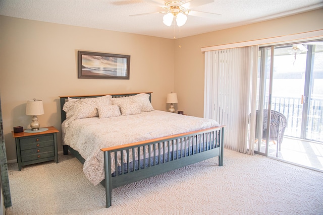 carpeted bedroom with ceiling fan, access to exterior, and a textured ceiling