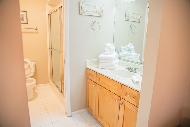 bathroom featuring tile patterned floors, vanity, toilet, and a shower with shower door