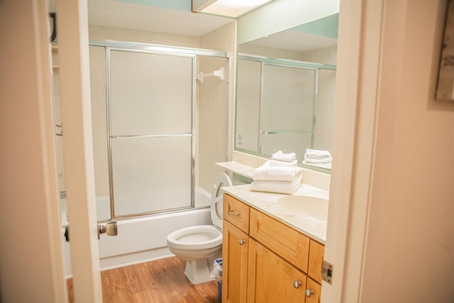 full bathroom with shower / bath combination with glass door, toilet, vanity, and hardwood / wood-style flooring