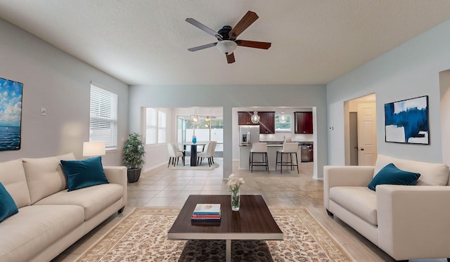 tiled living room featuring ceiling fan and a textured ceiling