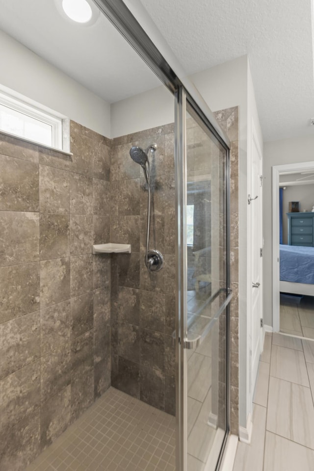 bathroom featuring a shower with door and a textured ceiling