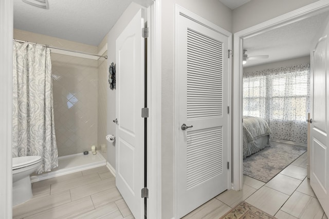 bathroom with tile patterned flooring, ceiling fan, a textured ceiling, and walk in shower