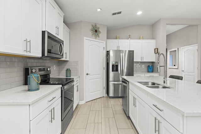 kitchen featuring an island with sink, appliances with stainless steel finishes, sink, and white cabinets