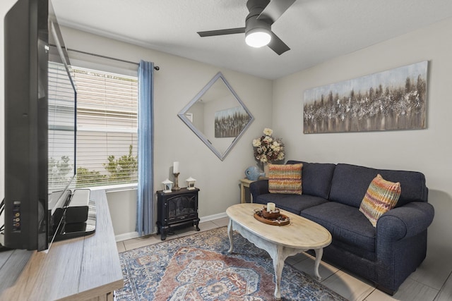 living room with a textured ceiling, tile patterned floors, and ceiling fan