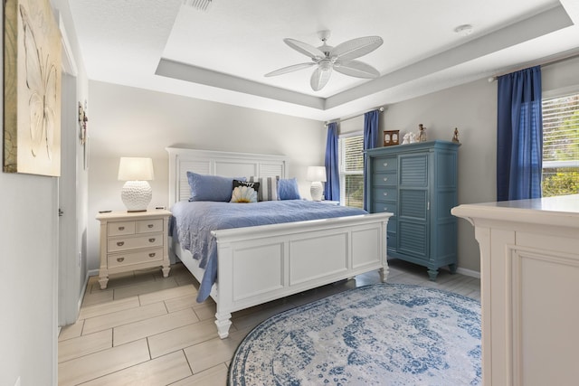 bedroom with a tray ceiling and ceiling fan