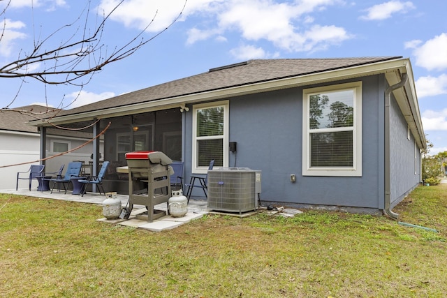 back of property featuring a sunroom, a patio area, a lawn, and central air condition unit