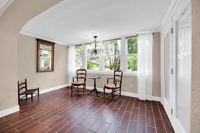 living area featuring crown molding, dark wood-type flooring, and a notable chandelier