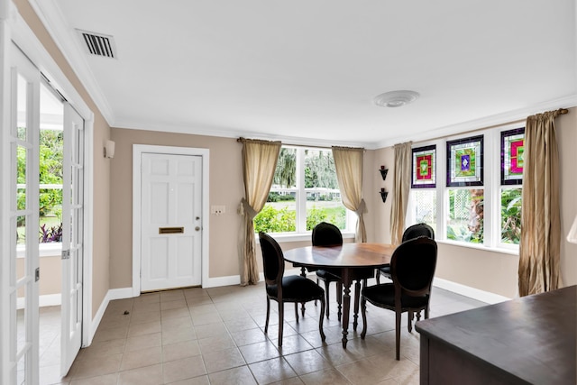 tiled dining space with plenty of natural light and crown molding