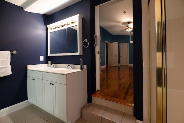 bathroom featuring a shower, wood-type flooring, vanity, and ceiling fan