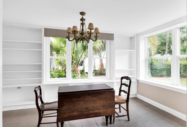 dining room with tile patterned flooring, built in features, and a notable chandelier