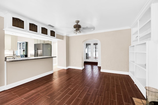 unfurnished living room with ceiling fan, french doors, dark hardwood / wood-style floors, and ornamental molding