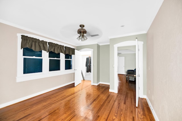 empty room with hardwood / wood-style flooring, ceiling fan, and ornamental molding