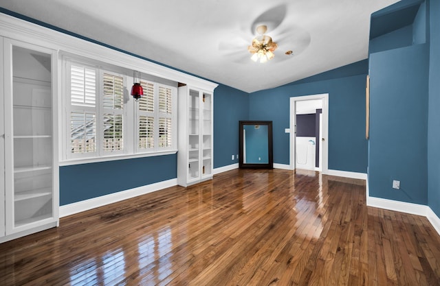 empty room featuring ceiling fan, lofted ceiling, and dark wood-type flooring