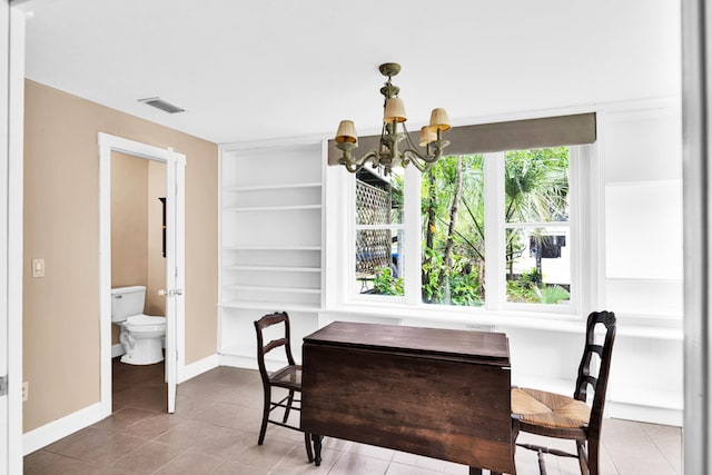 dining area with tile patterned floors, built in features, and an inviting chandelier