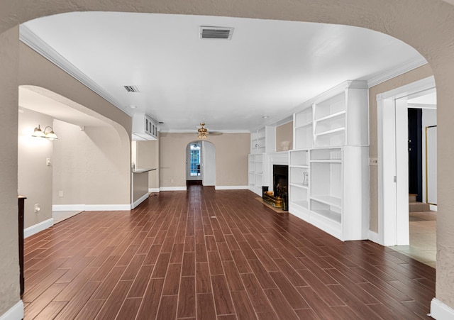 unfurnished living room featuring ceiling fan, dark hardwood / wood-style flooring, ornamental molding, and built in shelves