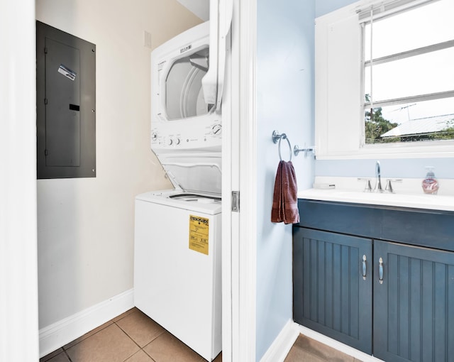 laundry room featuring light tile patterned floors, electric panel, stacked washer and clothes dryer, and sink