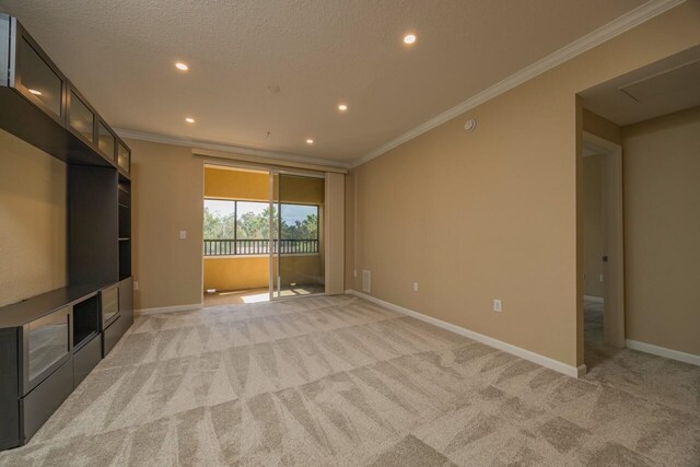 unfurnished living room featuring light carpet, ornamental molding, and a textured ceiling