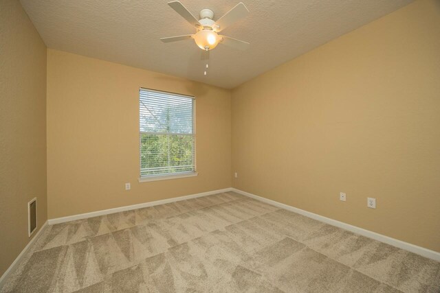 unfurnished bedroom with ensuite bathroom, light colored carpet, and a textured ceiling