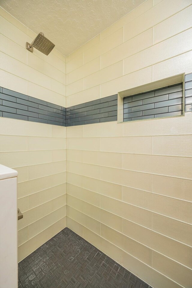 corridor featuring a textured ceiling and light tile patterned flooring