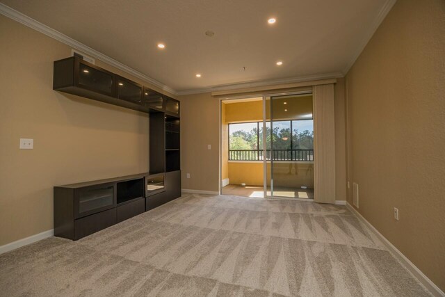 unfurnished living room with crown molding and light colored carpet