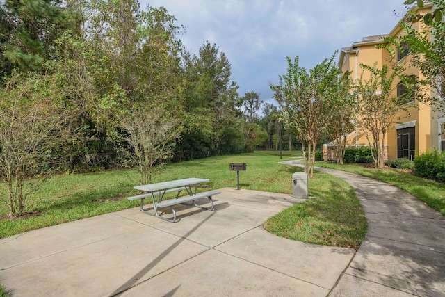 view of property's community featuring a patio area and a lawn