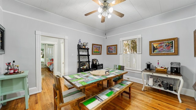 dining area featuring wood-type flooring and ceiling fan