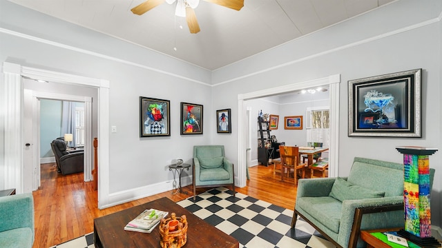 living area with wood-type flooring and ceiling fan