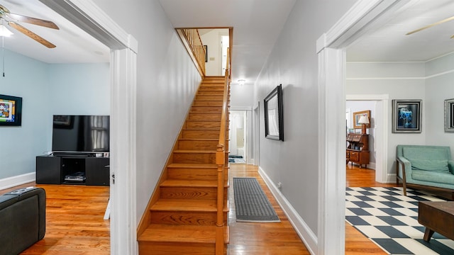 stairway with hardwood / wood-style flooring and ceiling fan