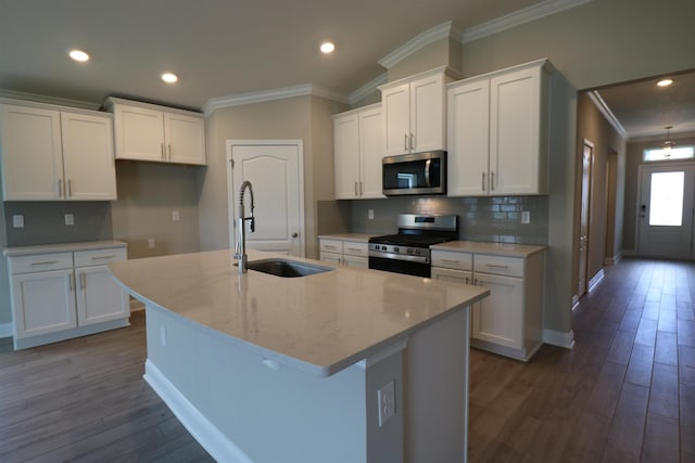 kitchen featuring appliances with stainless steel finishes, white cabinetry, an island with sink, sink, and dark wood-type flooring