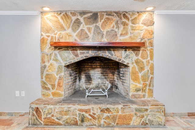 room details featuring a textured ceiling, a stone fireplace, and crown molding