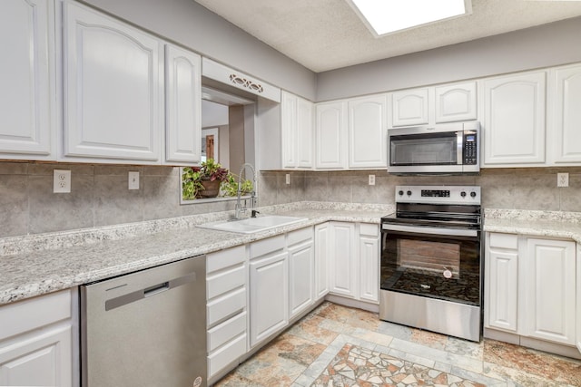 kitchen with white cabinets, backsplash, sink, and appliances with stainless steel finishes