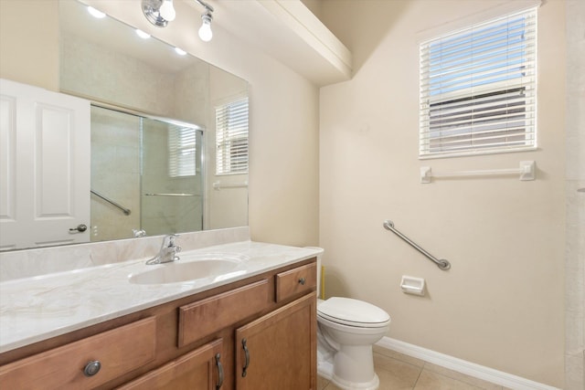 bathroom featuring tile patterned flooring, vanity, toilet, and a shower with door