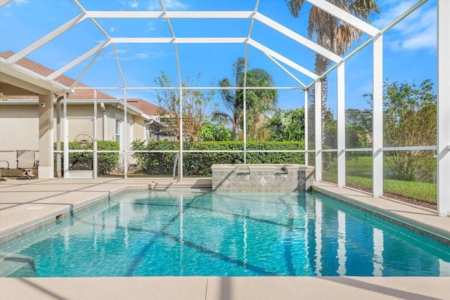 view of swimming pool with glass enclosure and a patio area