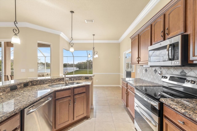 kitchen with sink, dark stone counters, decorative light fixtures, decorative backsplash, and appliances with stainless steel finishes