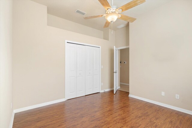 unfurnished bedroom with ceiling fan, a closet, and dark hardwood / wood-style floors