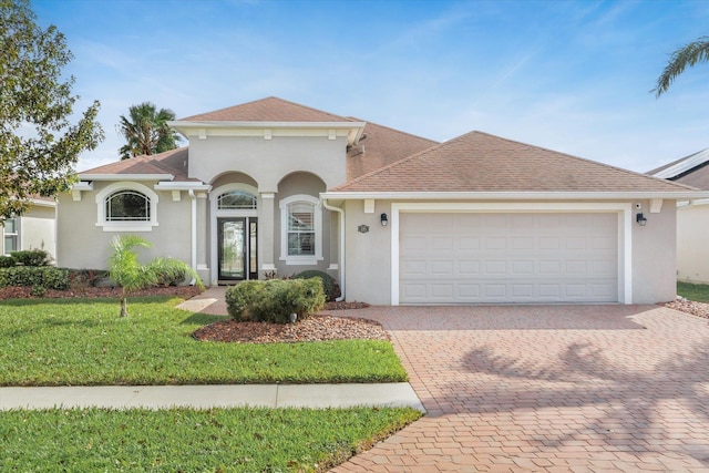 mediterranean / spanish-style home featuring a front lawn and a garage