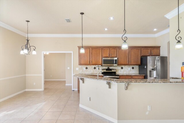 kitchen with appliances with stainless steel finishes, decorative light fixtures, and light stone counters