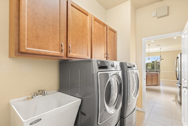 washroom with cabinets, sink, independent washer and dryer, light tile patterned floors, and ornamental molding