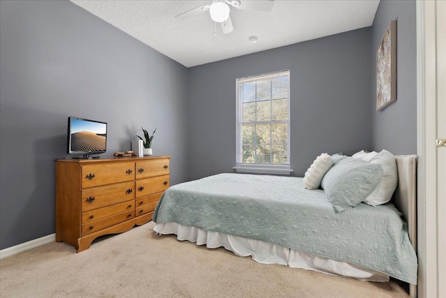 bedroom with baseboards, a textured ceiling, ceiling fan, and carpet flooring