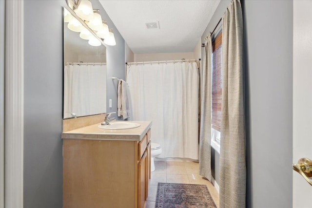 full bathroom featuring vanity, visible vents, tile patterned flooring, a textured ceiling, and toilet