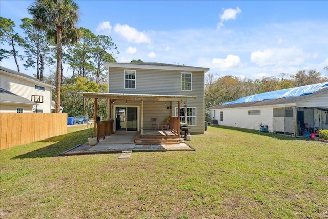 rear view of property featuring a yard, fence, and central AC