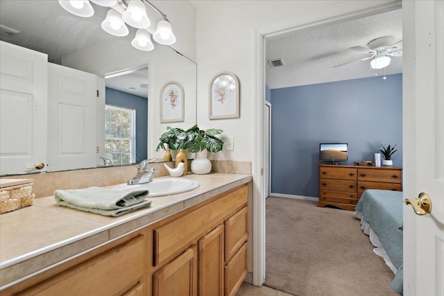 bathroom with visible vents, a textured ceiling, ceiling fan, and vanity